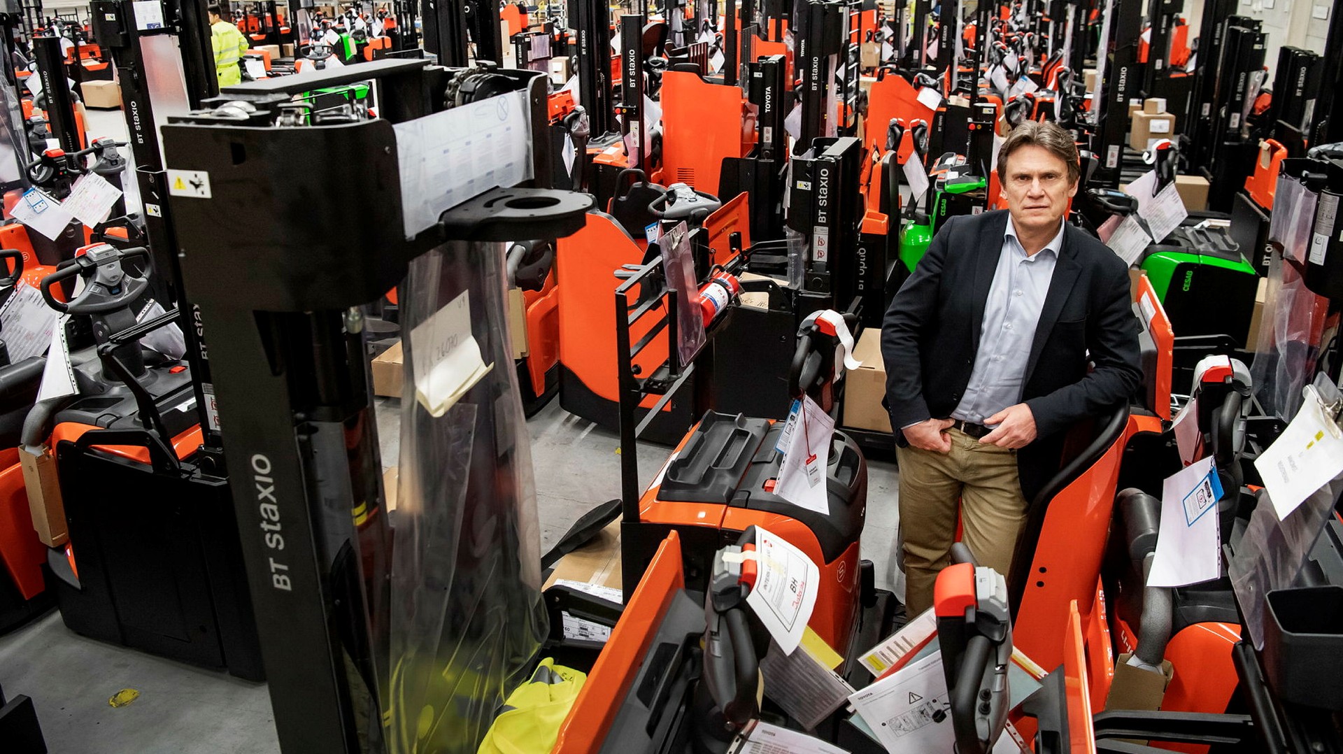 Vd:n Kristian Björkman i ett hav av gaffeltruckar med BT Staxio ingraverat på sidan.