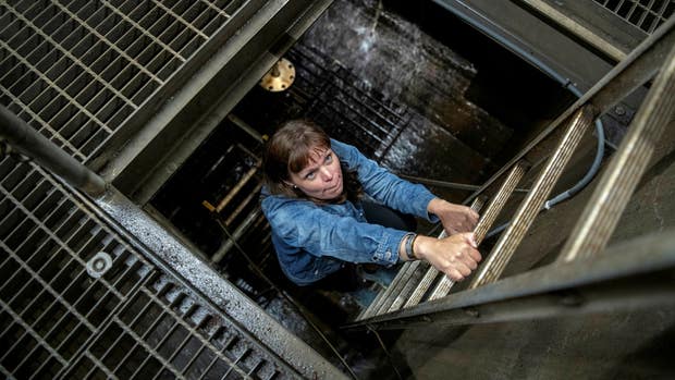Kommunekologen Linda Aldebert tar sig upp från den underjordiska knutpunkten för centrala och östra Katrineholms dagvattensystem.