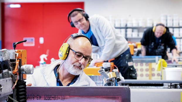 Amar Pierredal kalibrerar produktionslinan för tryckning på värmetransfers.