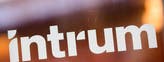 Kreditbolaget Intrums logotyp tryckt på ett något repigt fönster.