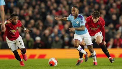 Manchester Citys Raheem Sterling, i mitten, and Manchester Uniteds Victor Nilsson Lindelöf, till höger, i kamp om bollen.